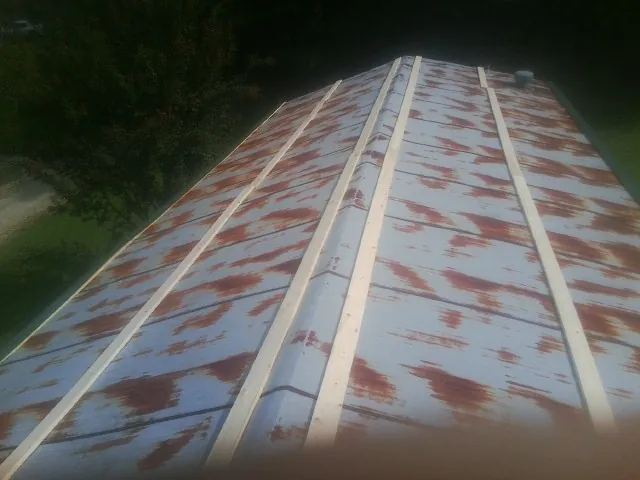 Rusted metal roof panels with new wood purlins before replacement — Storm Damage Roof Repair in Mill Neck by Roofing Brothers